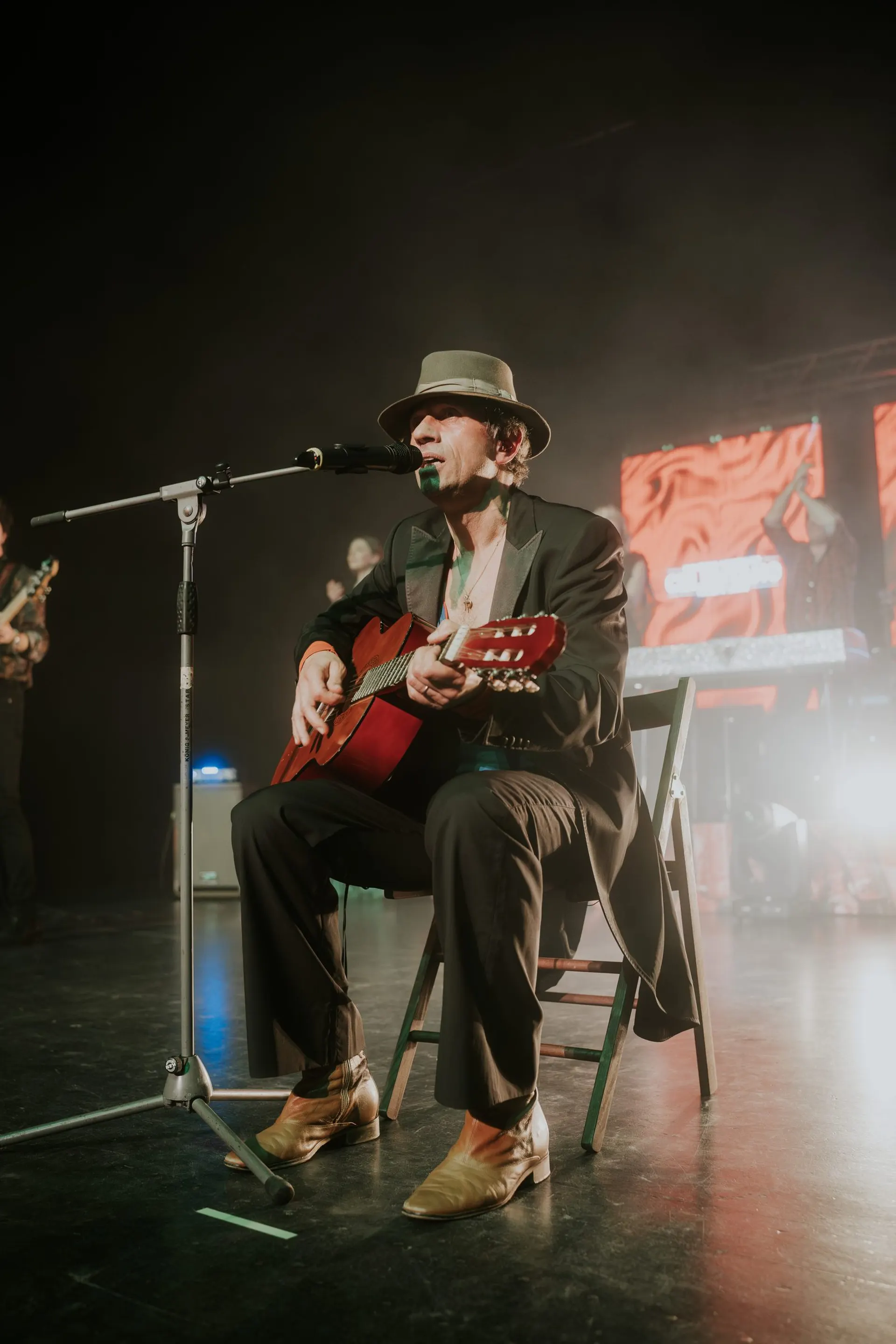 Maurizio Schweizer canta e suona la chitarra sotto una luce calda